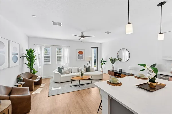 a living room with furniture a chandelier and a potted plant