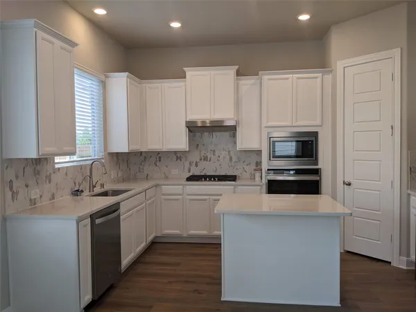 a kitchen with a sink cabinets and stainless steel appliances