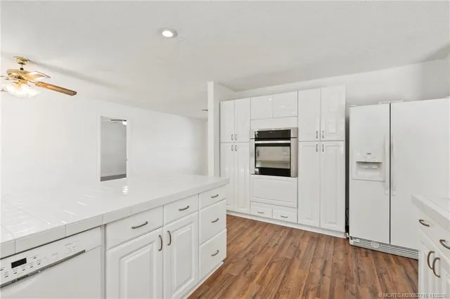 a kitchen with cabinets and wooden floor