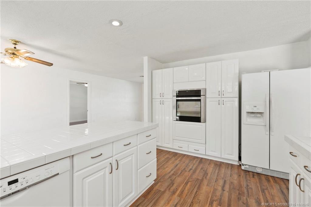 5801 Southeast Cable Drive Stuart, FL 34997 - Photo 11 of 48 a kitchen with cabinets and wooden floor