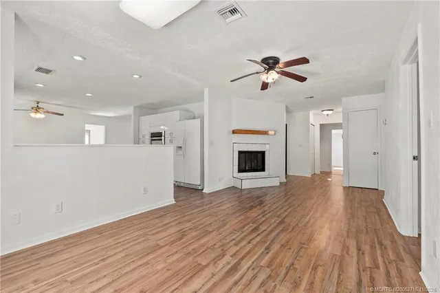 a view of a kitchen with wooden floor and a ceiling fan