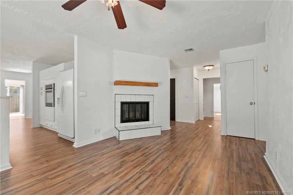 5801 Southeast Cable Drive Stuart, FL 34997 - Photo 18 of 48 a view of an empty room with wooden floor and a fireplace