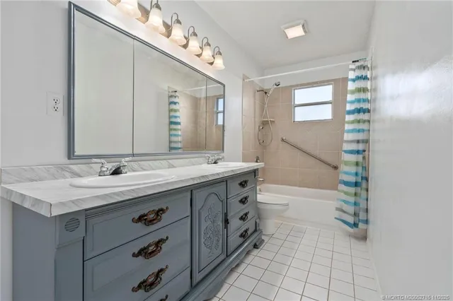 an empty room with wooden floor and fan