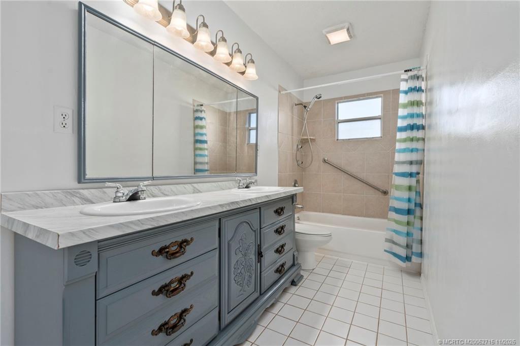 5801 Southeast Cable Drive Stuart, FL 34997 - Photo 29 of 48 a bathroom with a granite countertop sink a mirror and a bathtub