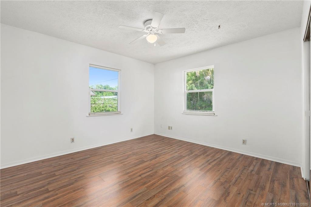 5801 Southeast Cable Drive Stuart, FL 34997 - Photo 31 of 48 an empty room with wooden floor and windows