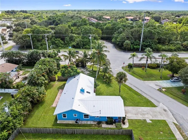 an aerial view of residential houses with outdoor space and trees all around