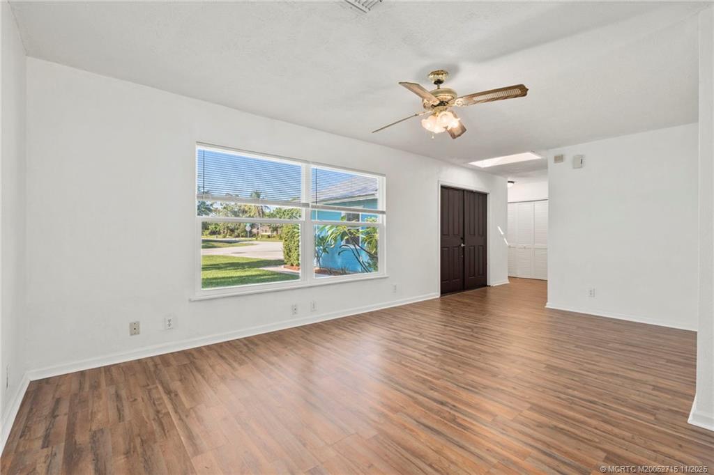 5801 Southeast Cable Drive Stuart, FL 34997 - Photo 7 of 48 an empty room with wooden floor a ceiling fan and windows