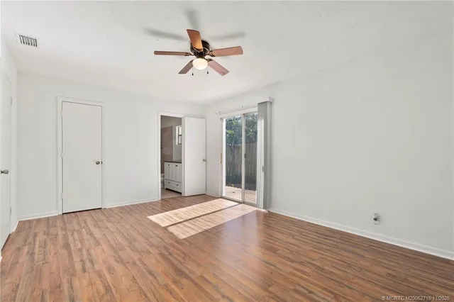 a view of a room with wooden floor and ceiling fan