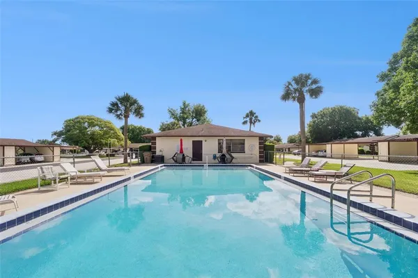 a view of a house with pool and chairs