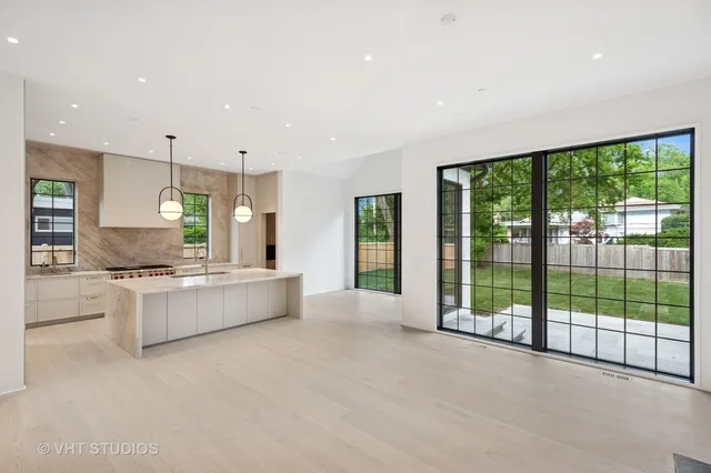 a large kitchen with kitchen island a large counter space a sink stainless steel appliances and cabinets