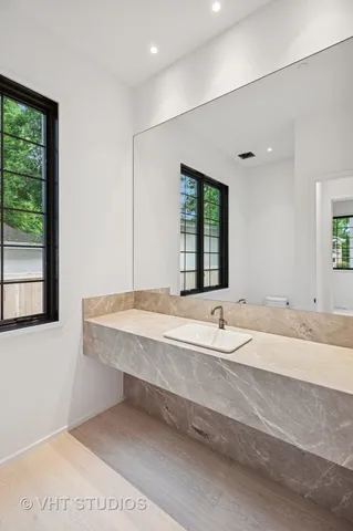 a bathroom with a granite countertop sink and a large mirror