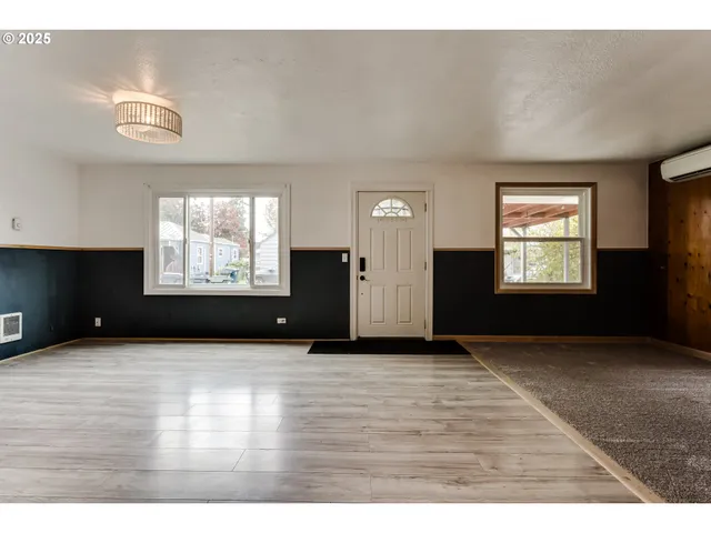 an empty room with windows and fireplace