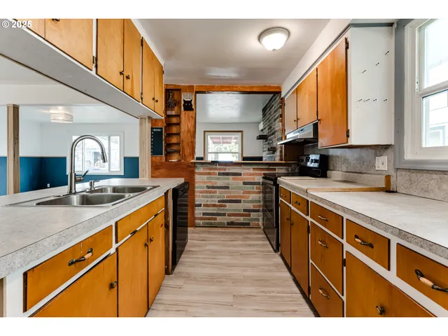 a large kitchen with stainless steel appliances granite countertop a lot of counter space and a sink