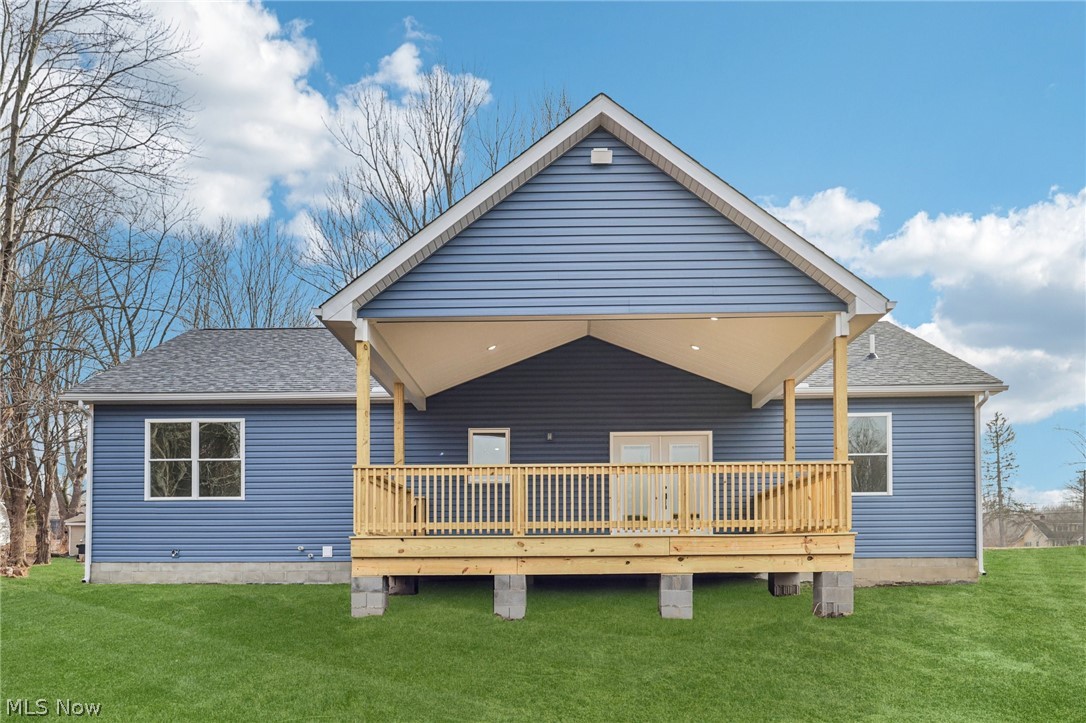 6535 North Ridge Road West Geneva, OH 44041 - Photo 38 of 48 Back of property featuring a shingled roof, a lawn, and a deck