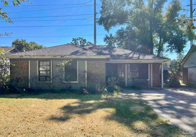 a front view of a house with a garden and yard
