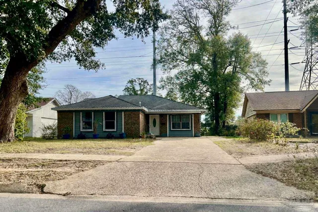 a view of a white house with a large tree