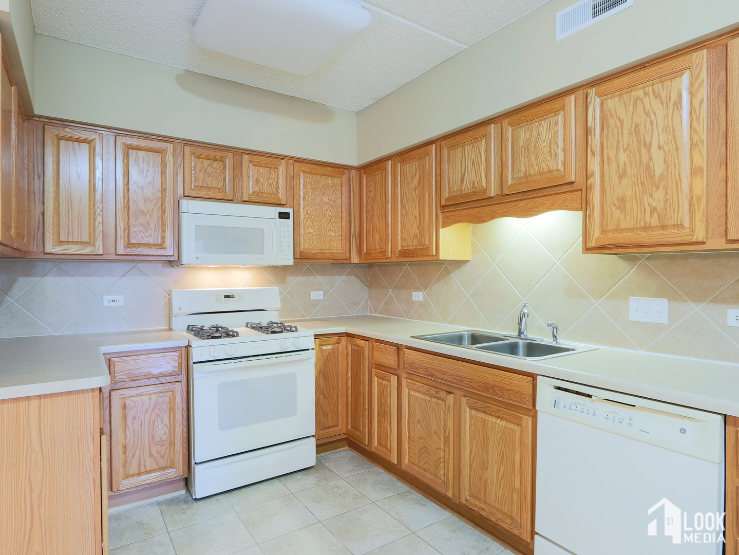 5 West Central Road, Unit 207 Mount Prospect, IL 60056 - Photo 7 of 29 a kitchen with cabinets appliances a sink and a window
