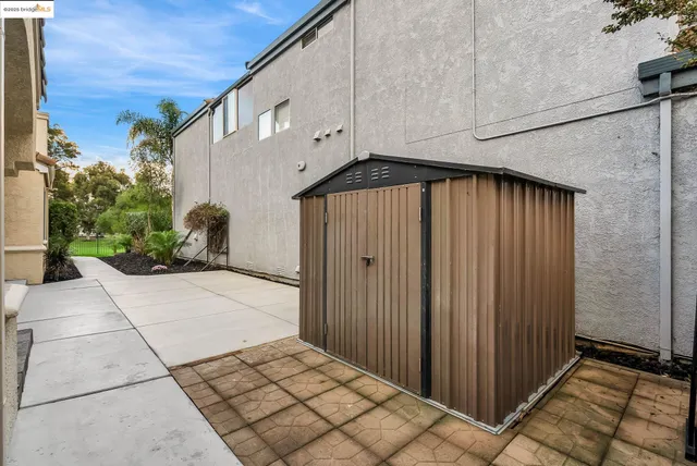 a view of an empty room with a window and kitchen view