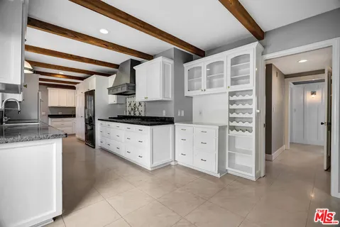 a kitchen with granite countertop a refrigerator oven a sink and dishwasher a large window