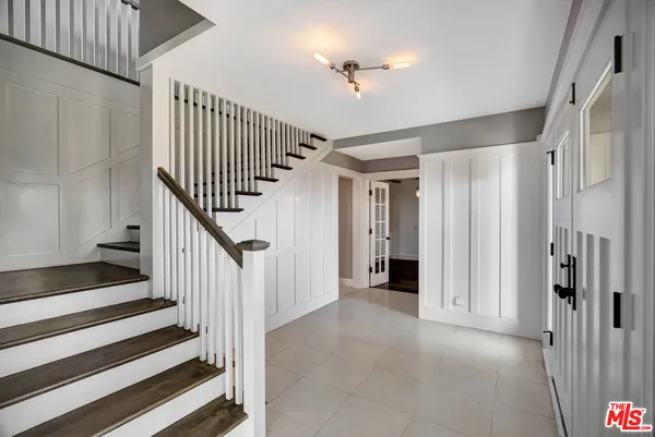 a view of an empty room with wooden floor fireplace and a window
