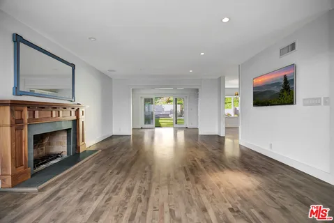 a living room with fireplace furniture and a wooden floor