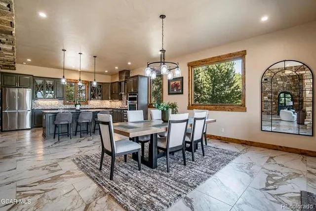 a dining room with furniture a chandelier and wooden floor
