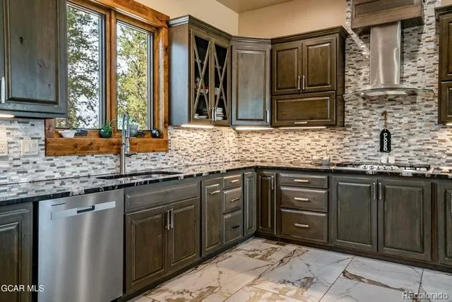 a kitchen with stainless steel appliances granite countertop cabinets sink and window