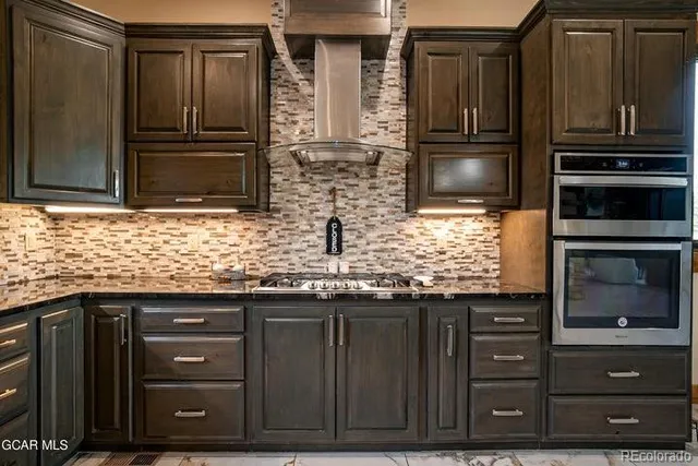 a kitchen with granite countertop wooden cabinets and stainless steel appliances