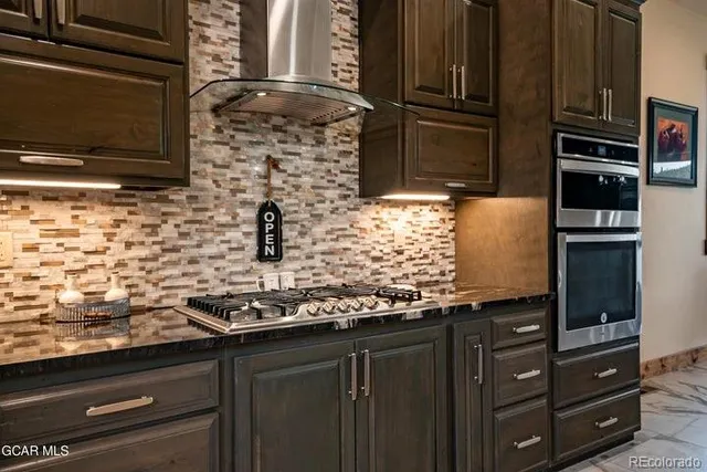 a kitchen with granite countertop a stove and cabinets