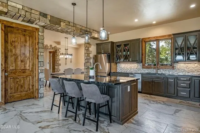 a kitchen with granite countertop a center island and a stove in it