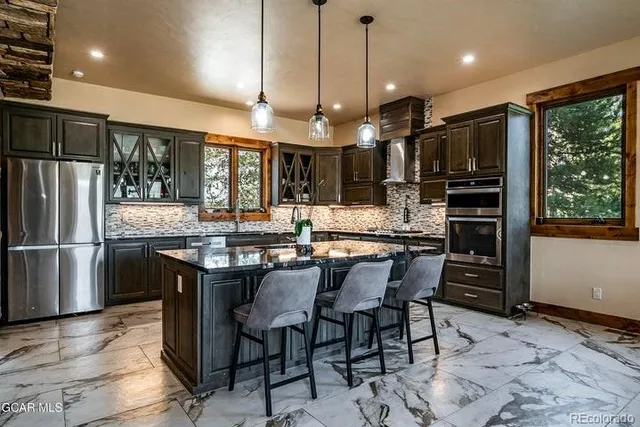 a kitchen with a table chairs refrigerator and microwave