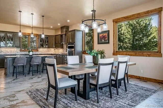 a dining room with furniture a chandelier and wooden floor