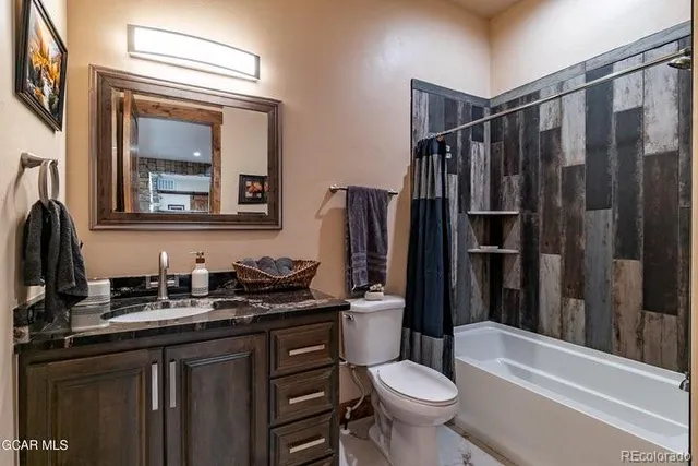 a bathroom with a sink a toilet a mirror and shower