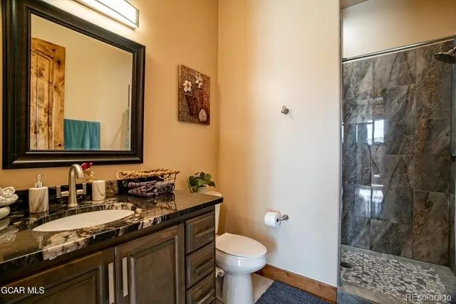 a bathroom with a granite countertop sink toilet and shower