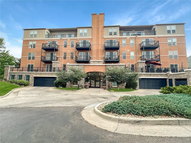 a front view of a building with a garden and plants
