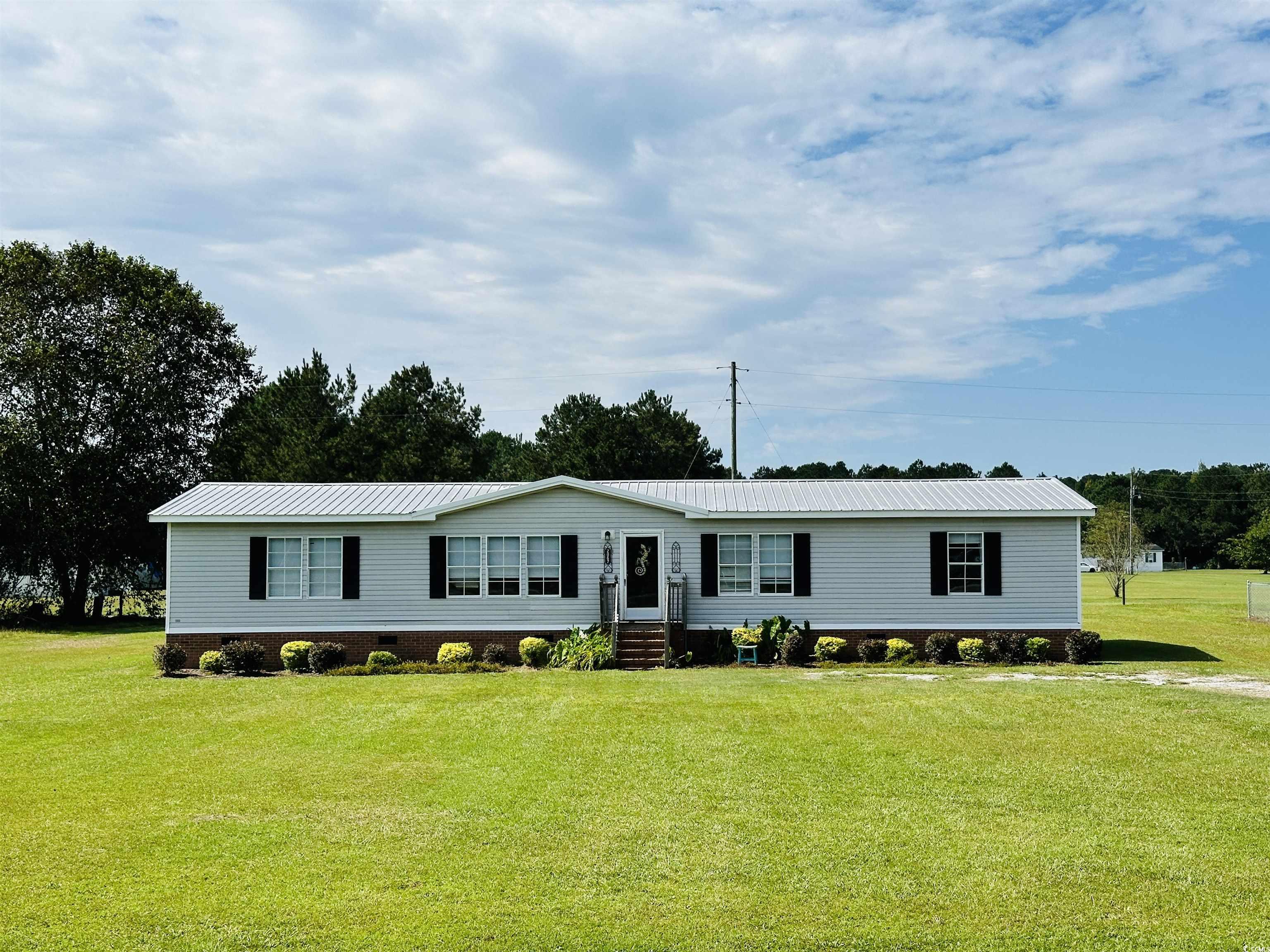 Manufactured / mobile home with a metal roof, a front yard, and entry steps
