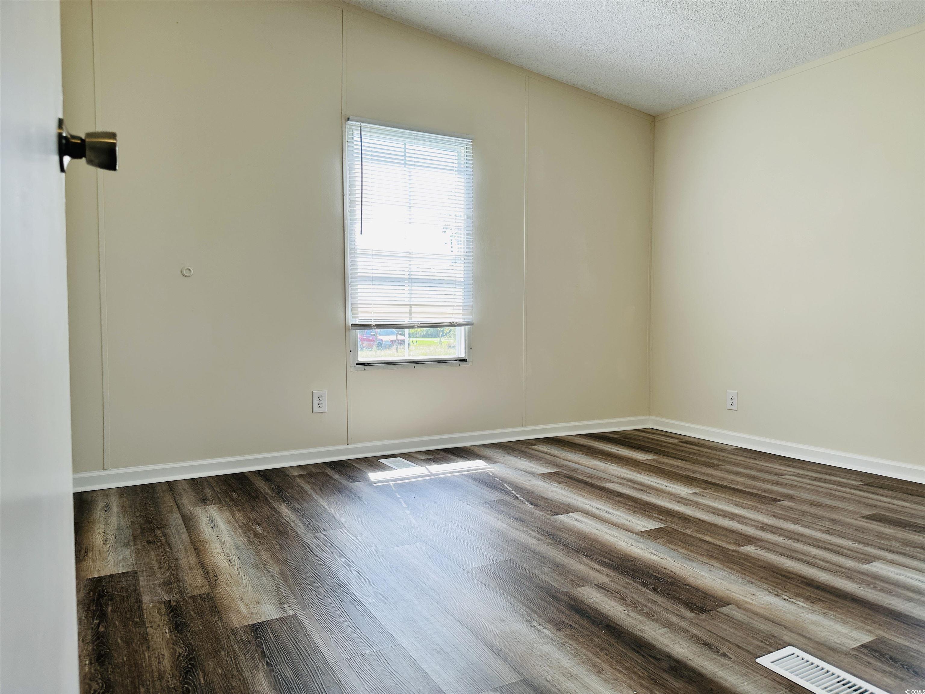 2067 Willow Creek Road Effingham, SC 29541 - Photo 15 of 40 Unfurnished room featuring dark wood-style flooring and a textured ceiling