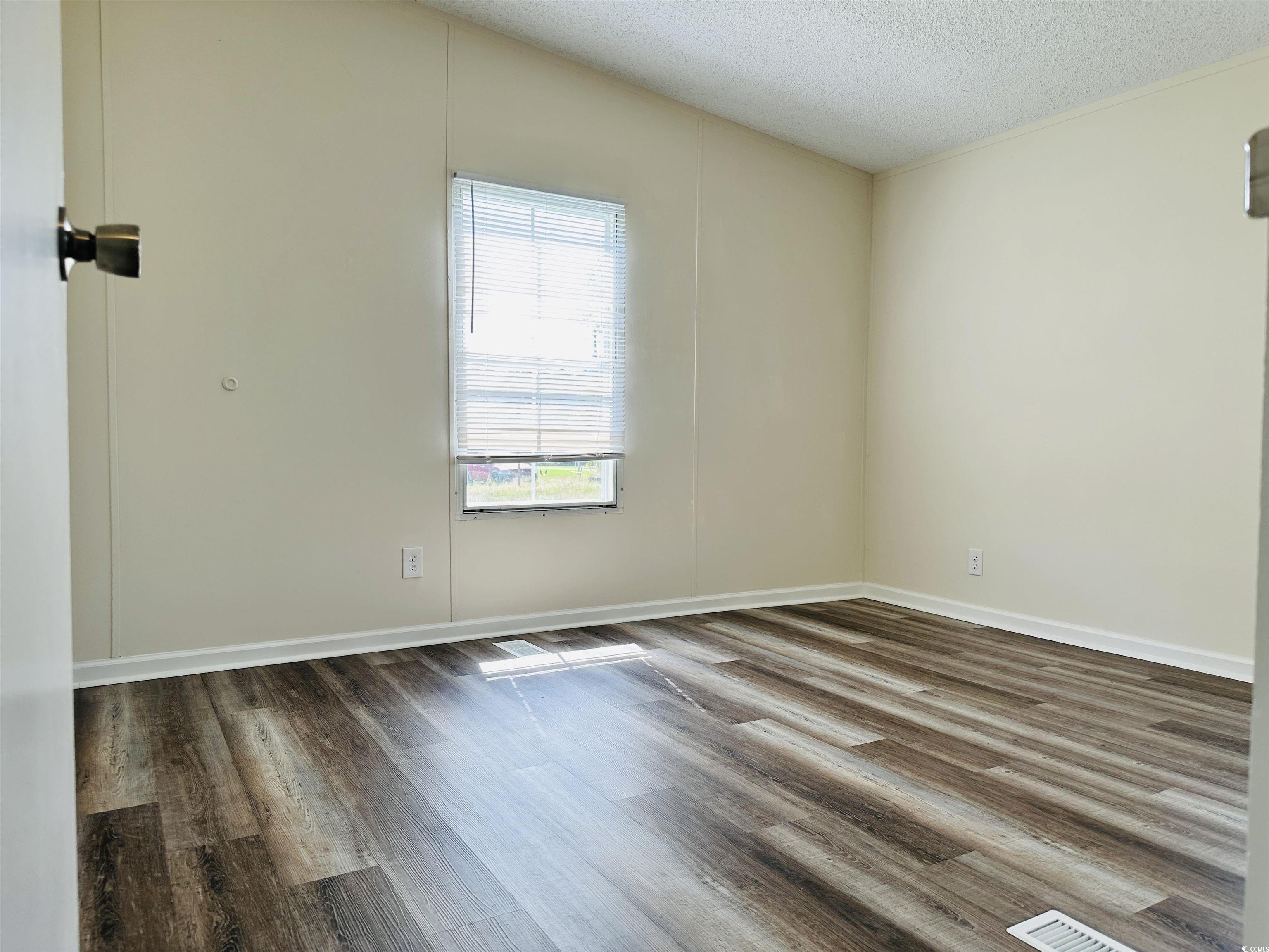 2067 Willow Creek Road Effingham, SC 29541 - Photo 16 of 40 Spare room featuring wood finished floors and a textured ceiling