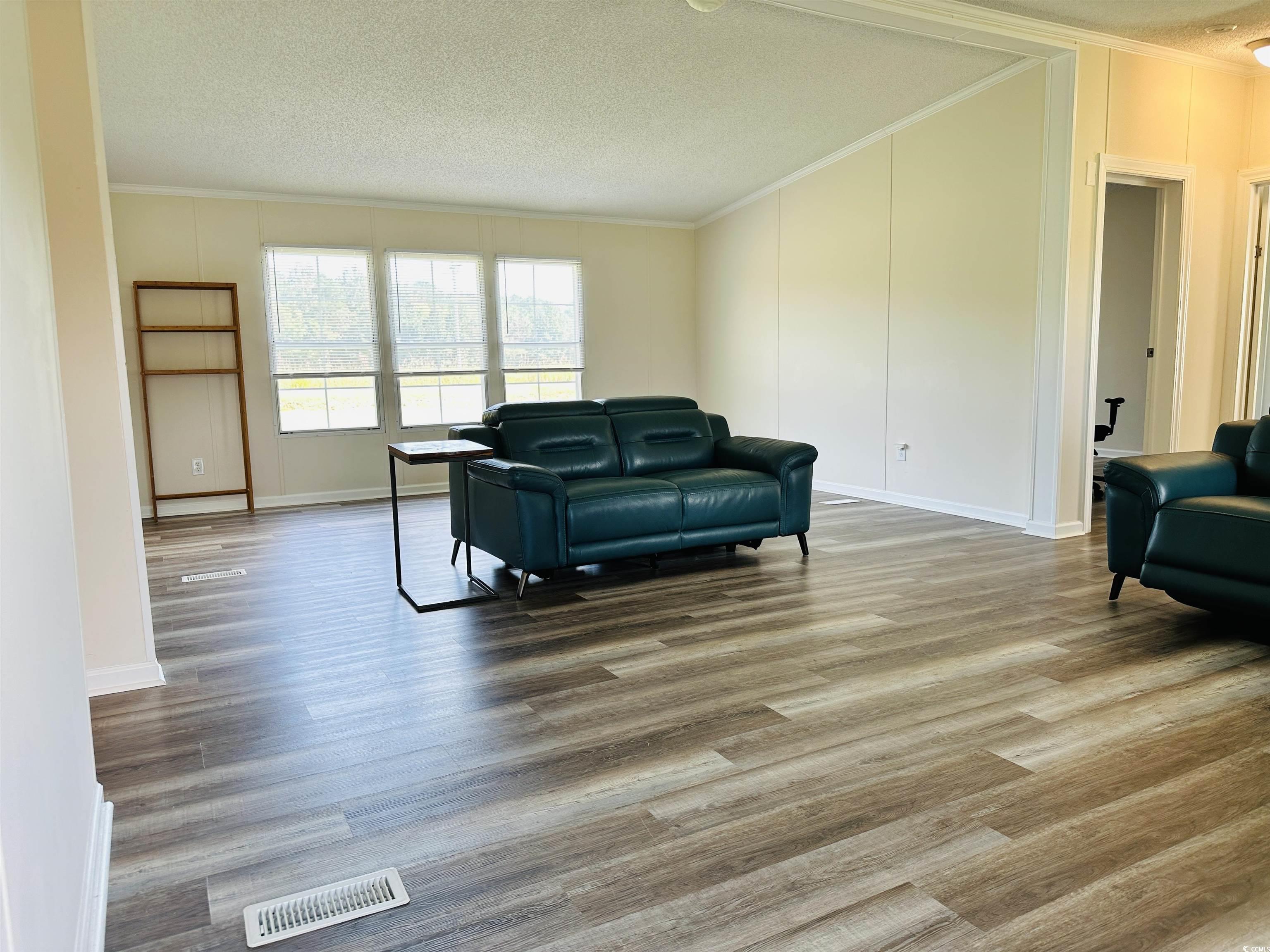 2067 Willow Creek Road Effingham, SC 29541 - Photo 24 of 40 Sitting room with crown molding, light wood-style floors, and a textured ceiling