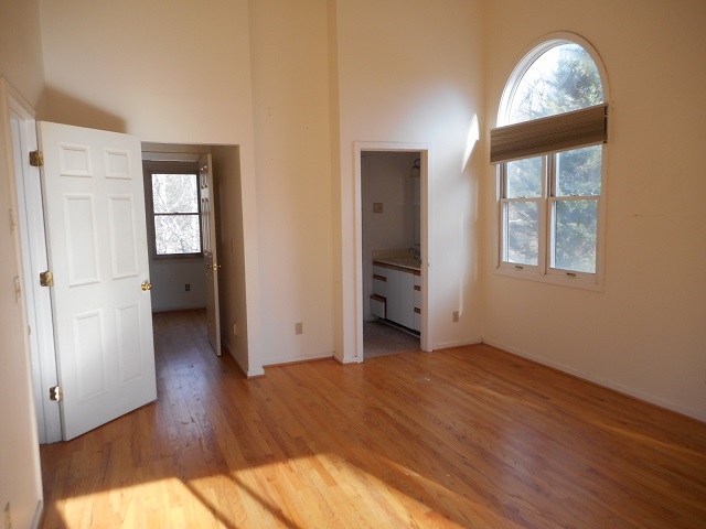 4201 Garth Road Charlottesville, VA 22901 - Photo 12 of 20 an empty room with wooden floor cabinet and windows