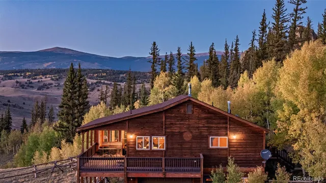 a front view of a house with a yard and mountain view in back