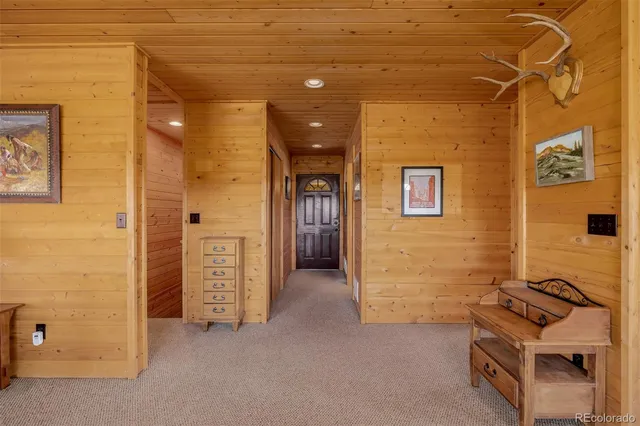 a living room with furniture a flat screen tv and floor to ceiling window