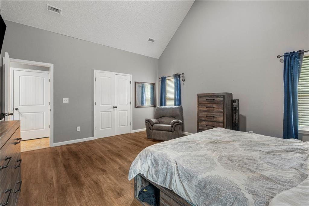 234 Owens Road Fort Mitchell, AL 36856 - Photo 13 of 25 Bedroom featuring high vaulted ceiling, wood finished floors, baseboards, and a closet