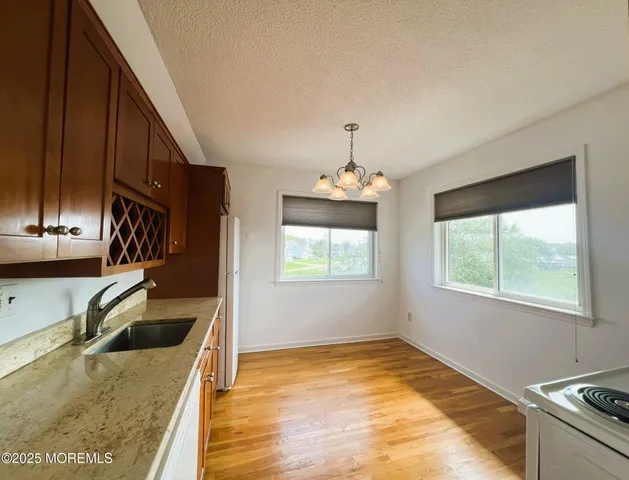 a view of a kitchen stove a sink and dishwasher with wooden floor