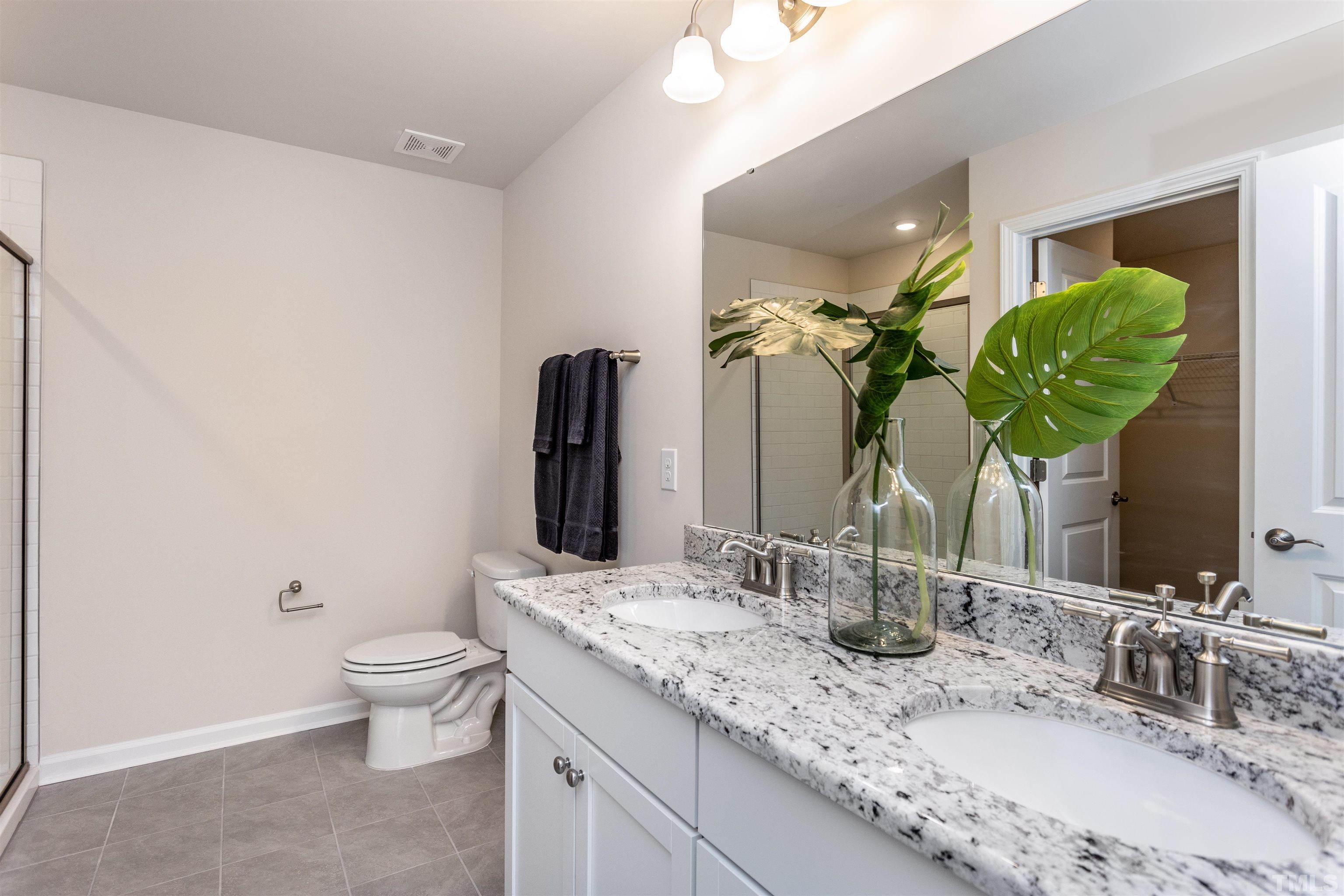 3469 Dragonfly River Raleigh, NC 27604 - Photo 22 of 26 a bathroom with a granite countertop sink a toilet and a mirror
