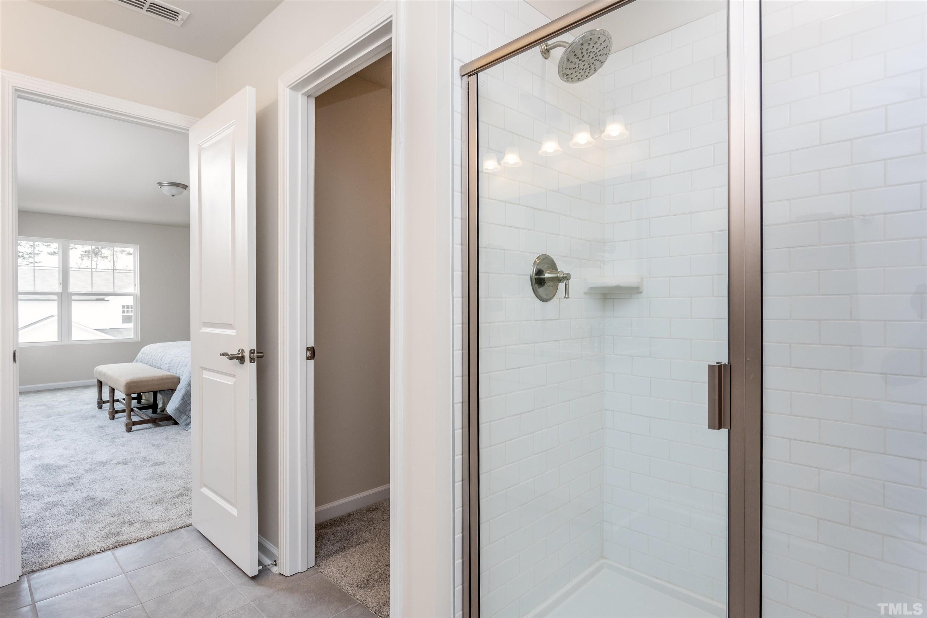3469 Dragonfly River Raleigh, NC 27604 - Photo 23 of 26 a bathroom with a glass shower door and a mirror