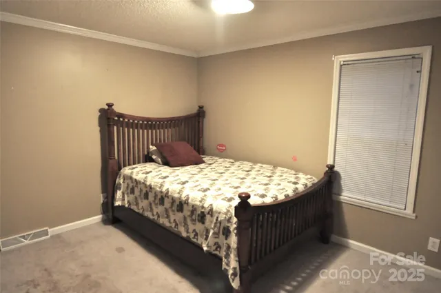 a bed sitting in a bedroom next to a window