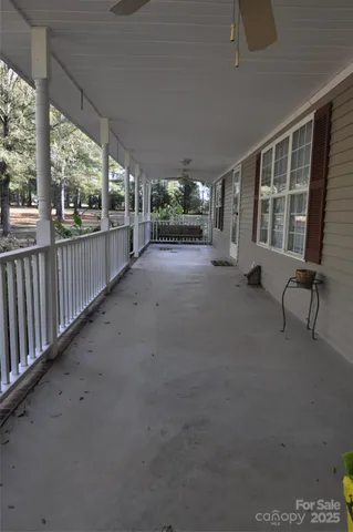 a view of a porch with furniture and floor to ceiling window