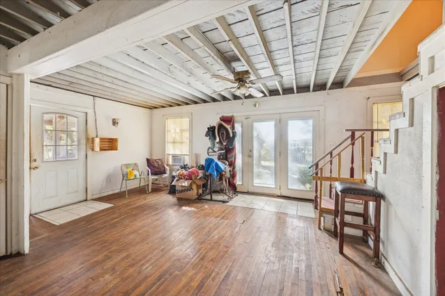 a view of a room with wooden furniture wooden floor and windows