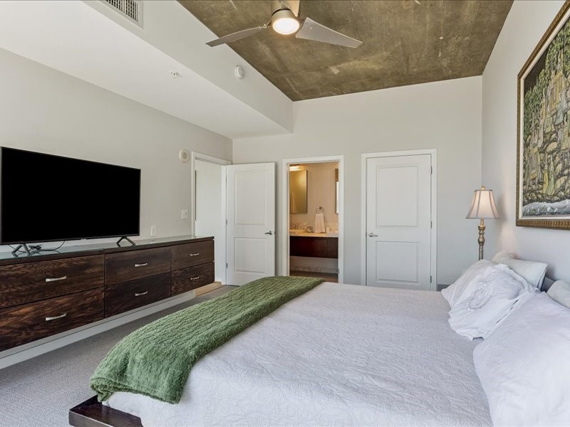 5925 Almeda Road, Unit 10714 Houston, TX 77004 - Photo 13 of 38 a bedroom with a bed and a flat screen tv